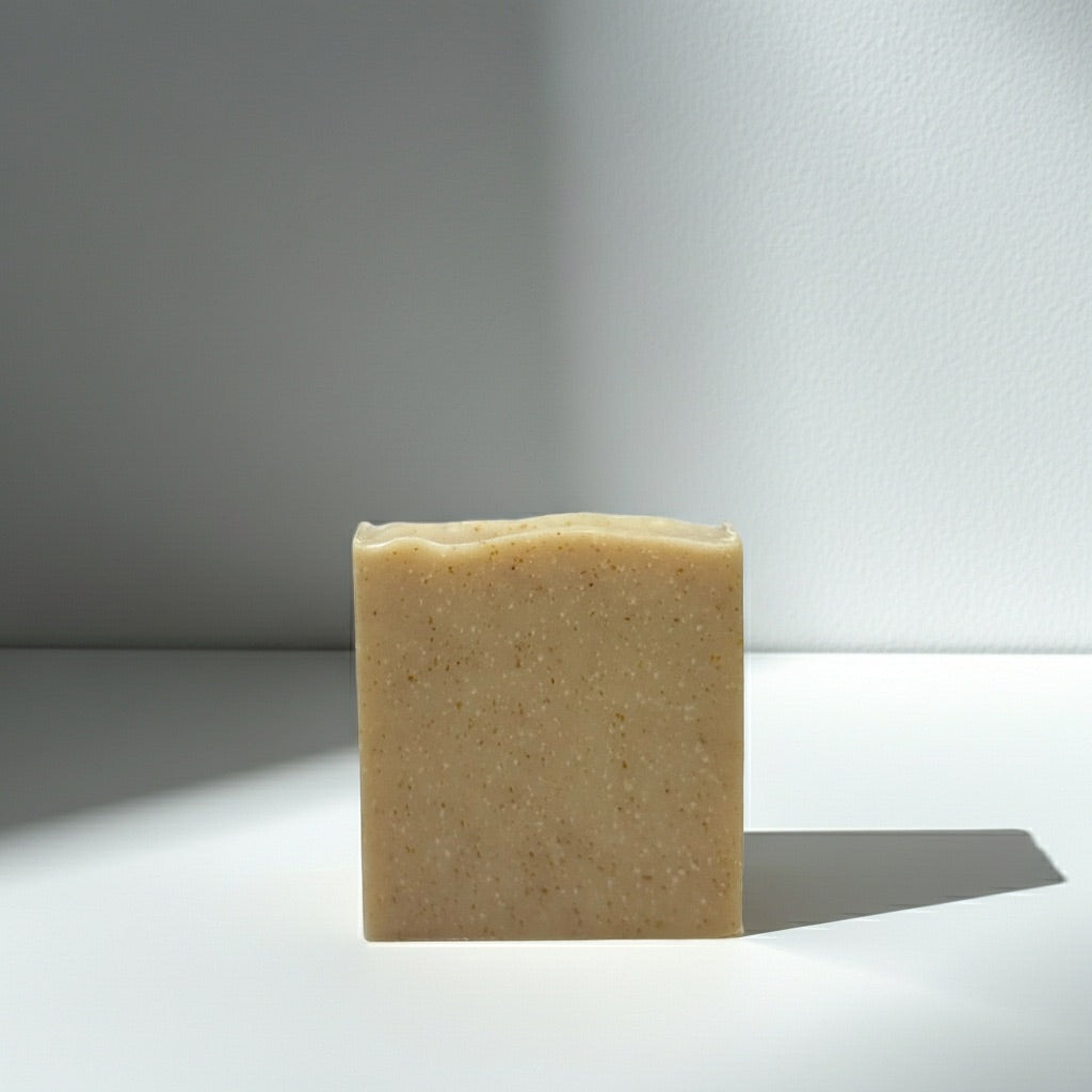 Bar of Oatmeal soap on a reflective surface with a gradient background